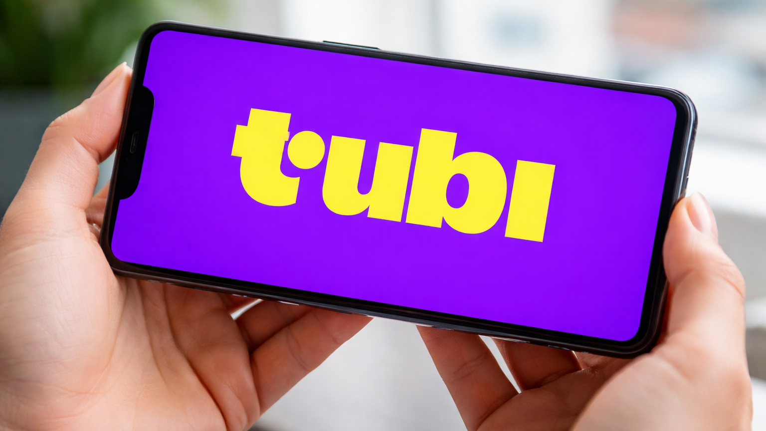 The Tubi logo on a phone screen.