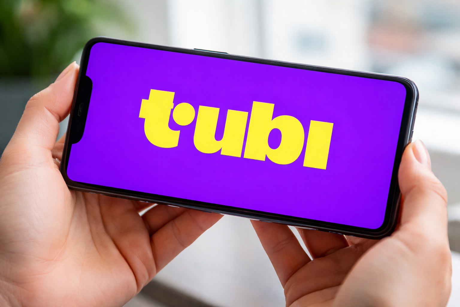 The Tubi logo on a phone screen.