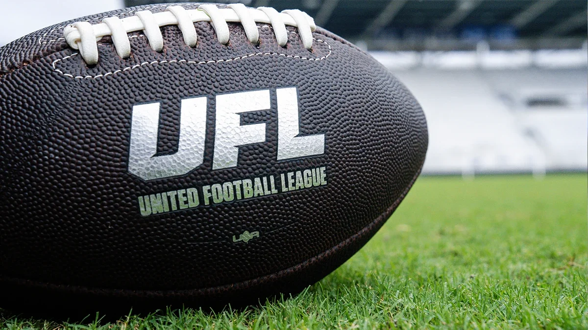A UFL football on a field.