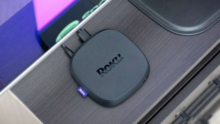 A Roku Ultra streaming device on a TV stand.
