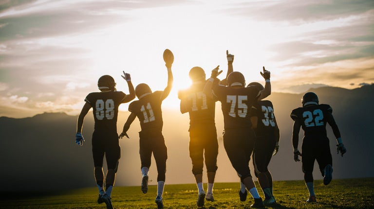 Football players on the field with a mountain view behind them