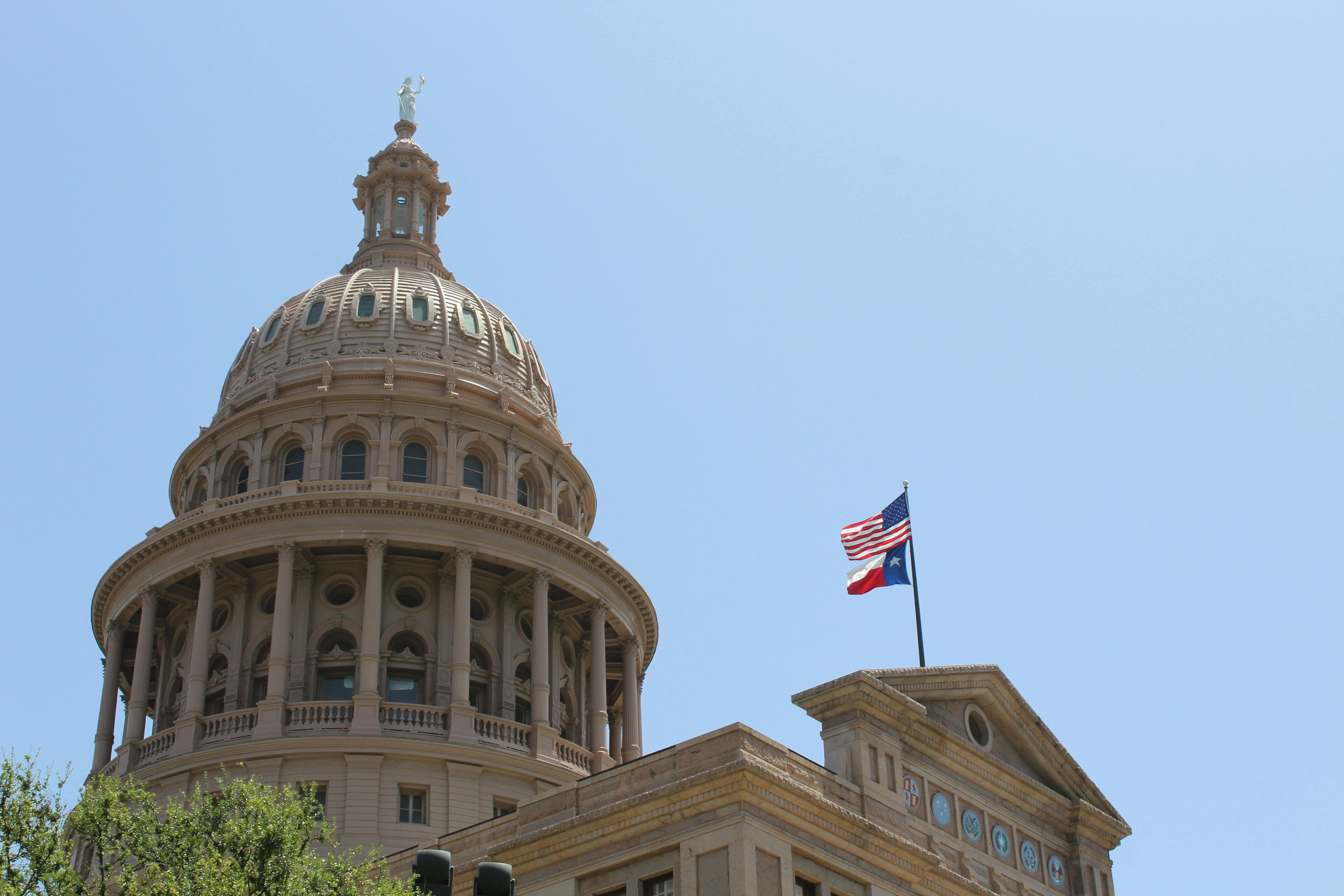 The flag of Texas flying over the statehouse.